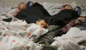 FILE This June 18, 2014, file photo, detainees sleep in a holding cell at a U.S. Customs and Border Protection, processing facility in Brownsville,Texas. Immigration courts backlogged by years of staffing shortages and tougher enforcement face an even more daunting challenge since tens of thousands of Central Americans began arriving on the U.S. border fleeing violence back home. For years, children from Central America traveling alone and immigrants who prove they have a credible fear of returning home have been entitled to a hearing before an immigration judge. (AP Photo/Eric Gay, Pool, File)