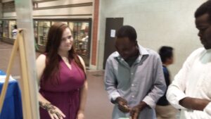 Appleseed Intern Olivia Rask (left) speaks with two recent refugees to Omaha at World Refugee Day.